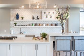 Elegant demonstration kitchen in the clubhouse, complete with snacks, beverages, and a premium coffee machine for your espresso, latte, or cappuccino fix